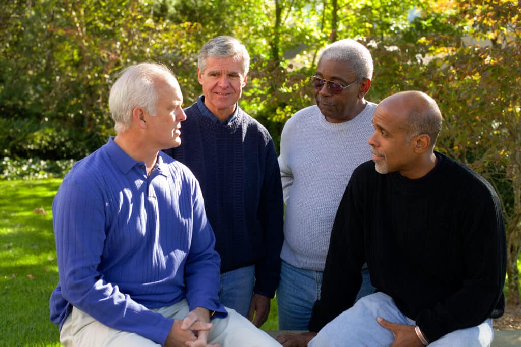 Four men speaking with each other